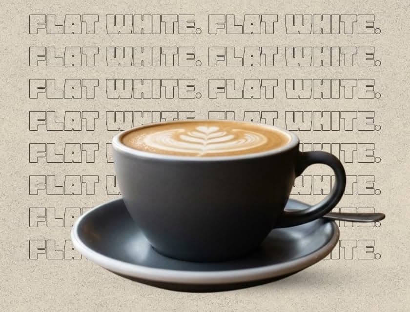 A flat white with rosetta latte art on a charcoal saucer